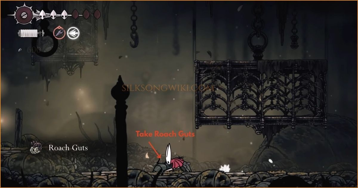 Hornet picks up a glowing Roach Gut item dropped by a defeated Muckroach.
